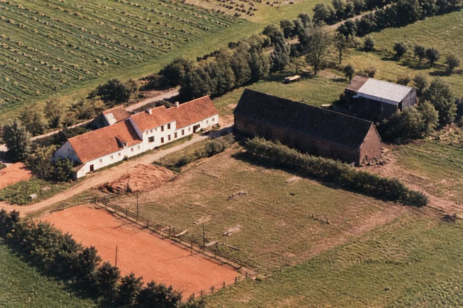 Luchtfoto van het achtererf van Hof Malleghem met schuren en omliggende velden, 1967